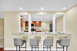 Kitchen area with bar top seating arrangement.  Kitchen area opens to living/dining area.  Hardwood flooring, new paint.