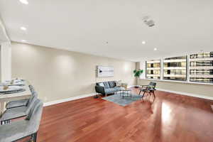 Living/dining studio space with hardwood flooring, new paint.