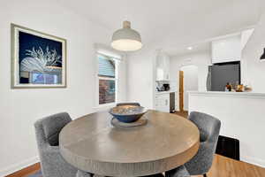 Dining area with crown molding and hardwood / wood-style flooring