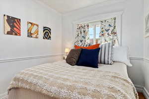 Bedroom featuring crown molding and hardwood / wood-style floors