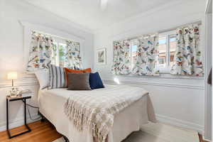 Bedroom featuring ornamental molding, multiple windows, light hardwood / wood-style floors, and ceiling fan