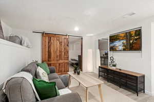 Living room featuring a barn door and light wood-type flooring