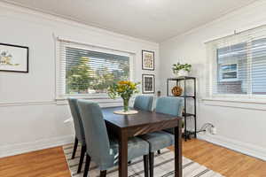 Dining space with ornamental molding, a textured ceiling, and wood-type flooring