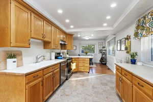 Kitchen featuring kitchen peninsula, stainless steel appliances, sink, and crown molding