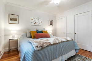 Bedroom with ornamental molding, hardwood / wood-style floors, and ceiling fan