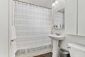 Full bathroom featuring sink, toilet, crown molding, and shower / tub combo