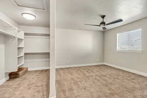 Spacious closet featuring light carpet and ceiling fan