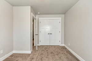 Bedroom 2: Unfurnished bedroom with a closet and light carpet