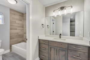 Master bathroom featuring tiled shower / bath, vanity, and toilet