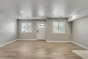 Entrance foyer with a textured ceiling and light hardwood / wood-style floors