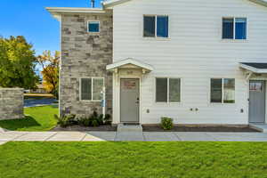 View of front of the end-unit townhome, featuring a front lawn