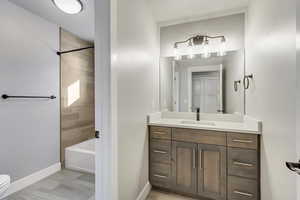 Full bath 2: Full bathroom featuring chic vanity, and tiled shower / bath combo