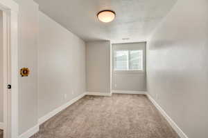 Bedroom 3: Carpeted spare room featuring a textured ceiling