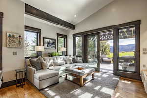 Living room with a mountain view, wood-type flooring, and lofted ceiling