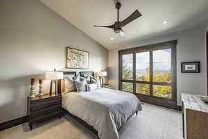 Bedroom featuring light carpet, vaulted ceiling, and ceiling fan