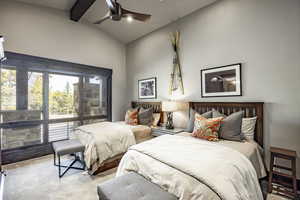 Bedroom with lofted ceiling with beams, light colored carpet, and ceiling fan