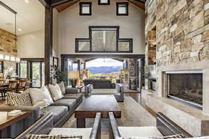 Living room with hardwood / wood-style flooring, a mountain view, a fireplace, and high vaulted ceiling