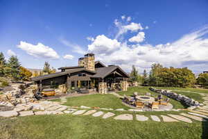 Back of house featuring a lawn, a patio area, area for grilling, and a fire pit