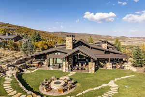 Rear view of property featuring a patio area, a mountain view, and a yard