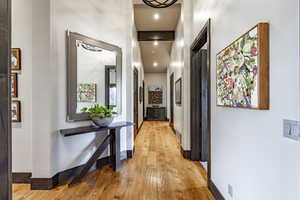 Corridor with a towering ceiling and light hardwood / wood-style flooring