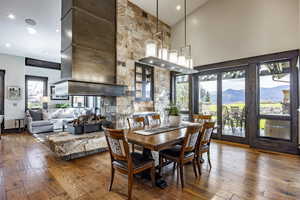 Dining room with a mountain view, hardwood / wood-style floors, and high vaulted ceiling