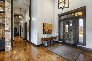 Entryway featuring hardwood / wood-style floors, a high ceiling, and a chandelier