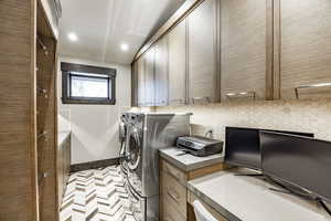 Clothes washing area with tile patterned flooring, cabinets, and independent washer and dryer