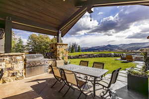 View of patio with a mountain view, area for grilling, and a grill