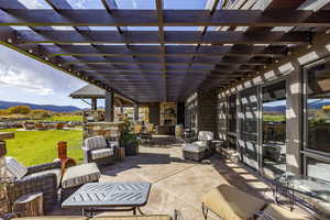 View of patio with a pergola, a mountain view, and an outdoor living space with a fireplace