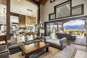 Living room with beam ceiling, high vaulted ceiling, wooden ceiling, a mountain view, and light hardwood / wood-style floors