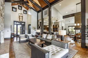 Living room with beam ceiling, wooden ceiling, high vaulted ceiling, hardwood / wood-style floors, and a fireplace