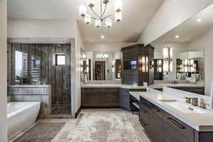 Bathroom featuring a notable chandelier, vanity, and separate shower and tub