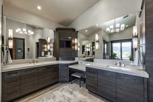 Bathroom featuring an inviting chandelier, vanity, vaulted ceiling, and hardwood / wood-style flooring