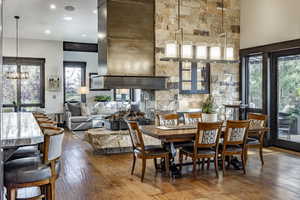 Dining area featuring hardwood / wood-style floors, a notable chandelier, and a high ceiling