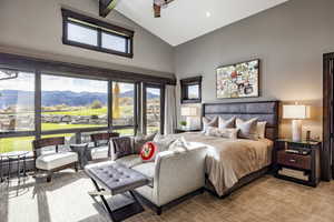 Carpeted bedroom with beamed ceiling, a mountain view, ceiling fan, and high vaulted ceiling