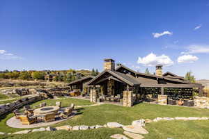 Back of house featuring a lawn, a fireplace, and a patio