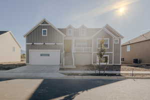 View of front of home featuring cooling unit and a garage