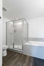 Bathroom with independent shower and bath, hardwood / wood-style floors, and toilet