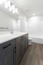 Full bathroom featuring  shower combination, vanity, wood-type flooring, and toilet