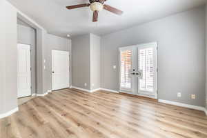 Empty room with french doors, light wood-type flooring, and ceiling fan