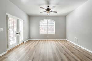 Empty room with light hardwood / wood-style flooring and ceiling fan