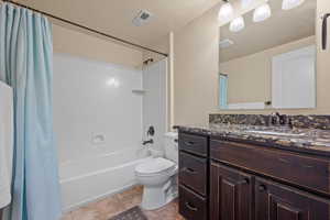 Full bathroom with vanity, shower / tub combo, and toilet