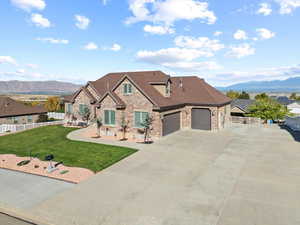 View of front of house featuring a mountain view, a front lawn, and a garage