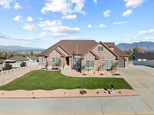 View of front of house with a mountain view, a front yard, and a garage