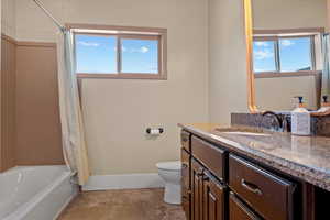 Full bathroom with vanity, toilet, a wealth of natural light, and shower / tub combo with curtain