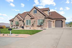 View of front of home featuring a garage, a front lawn, and a mountain view