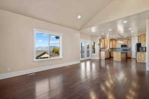 Living room with french doors, a mountain view, high vaulted ceiling, and dark hardwood / wood-style floors