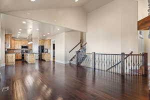 Living room with sink, high vaulted ceiling, and dark hardwood / wood-style flooring