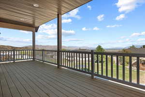 Deck with a mountain view and a lawn