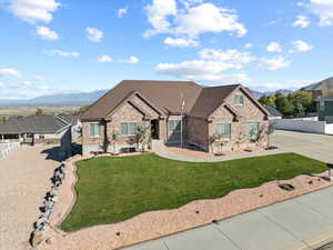 View of front of home with a mountain view and a front lawn